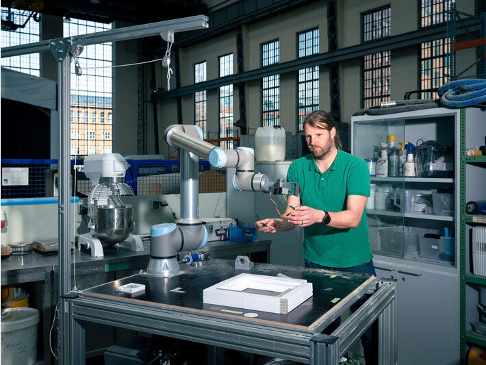 Mit diesem kleinen Roboterarm erforschen Timo Hartmann und sein Team, wie einglasige Fenster demontiert und zu mehrglasigen Fenstern wieder zusammengesetzt werden können. Der Roboterarm steht in der Peter-Behrens-Halle der TU Berlin.